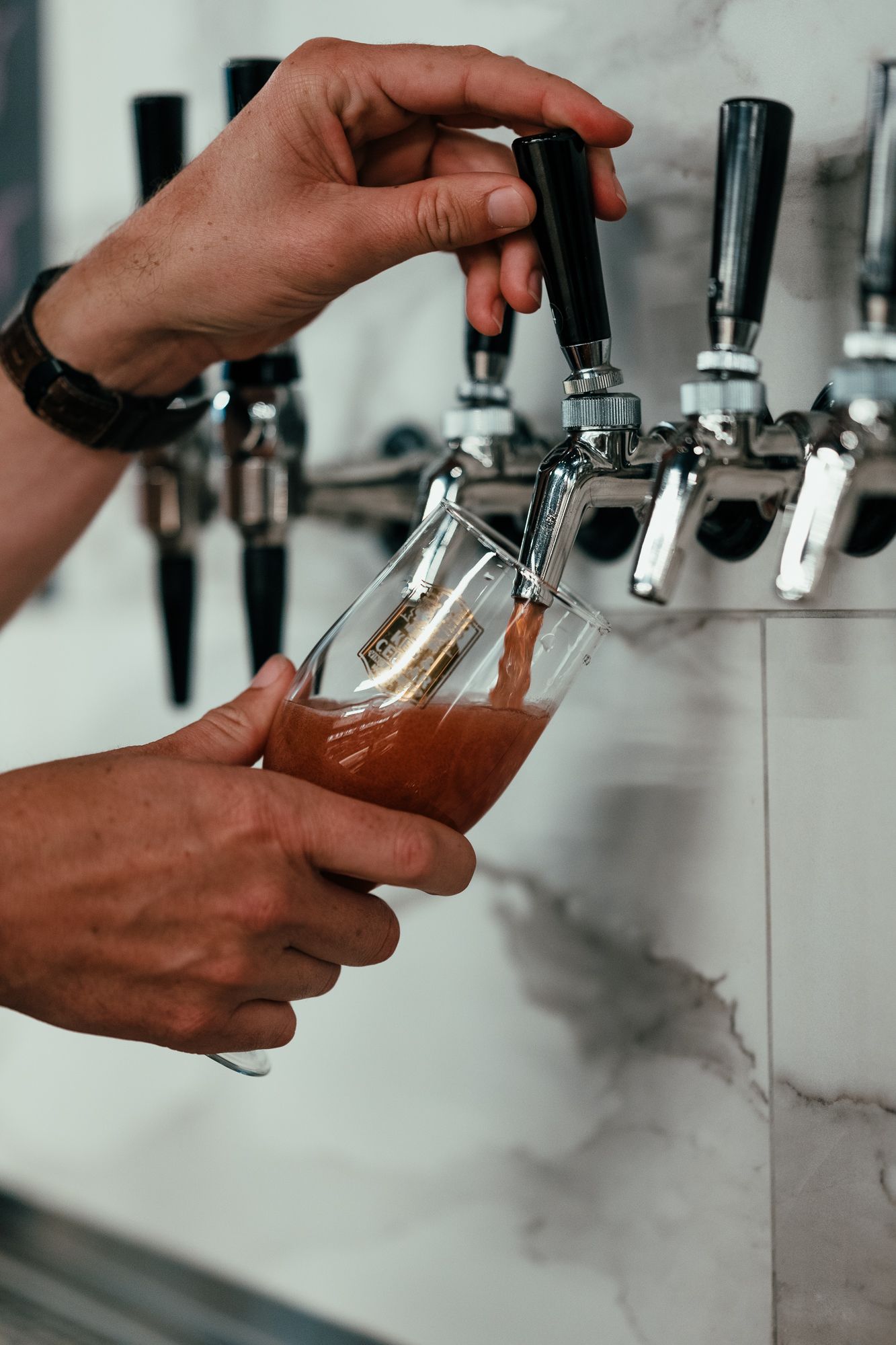 Bartender pouring a draft beer from the taps