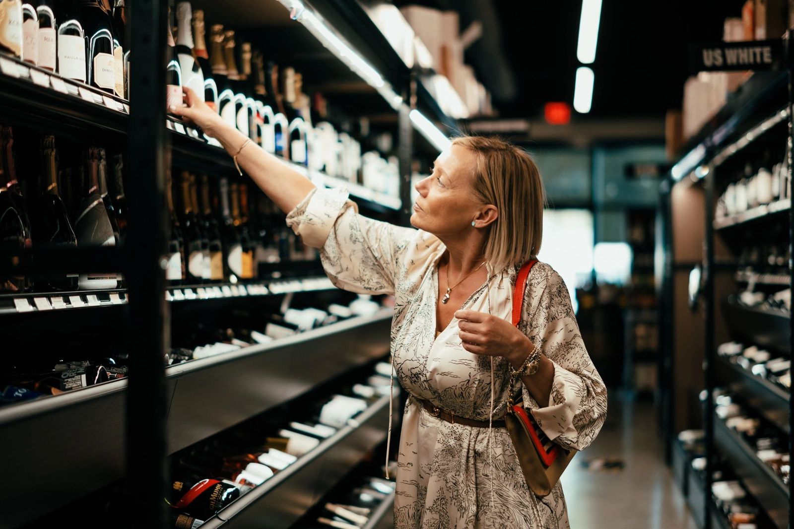 A customer browsing the wine shelves